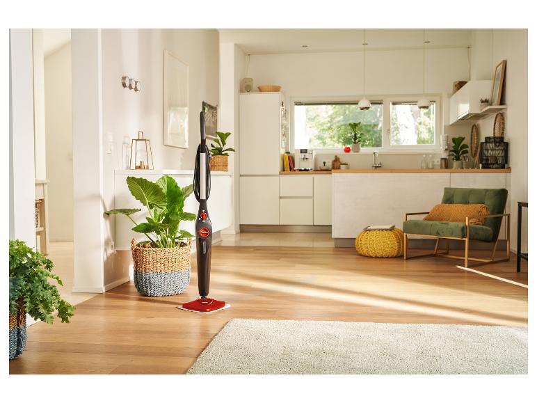 Stoommop in een moderne woonkamer met houten vloer en planten.