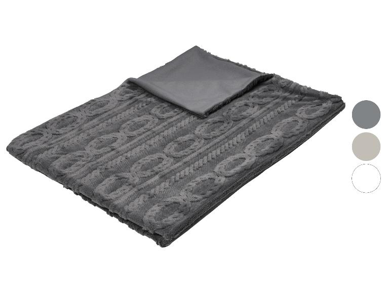 Een grijs kabelgebreid deken met een gladde grijze onderkant, getoond met kleurstalen.