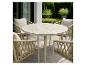 Buiten eethoek met ronde tafel en vier gevlochten stoelen op een terras.