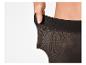 Close-up van een hand die de elastische tailleband van een zwarte panty uitrekt.