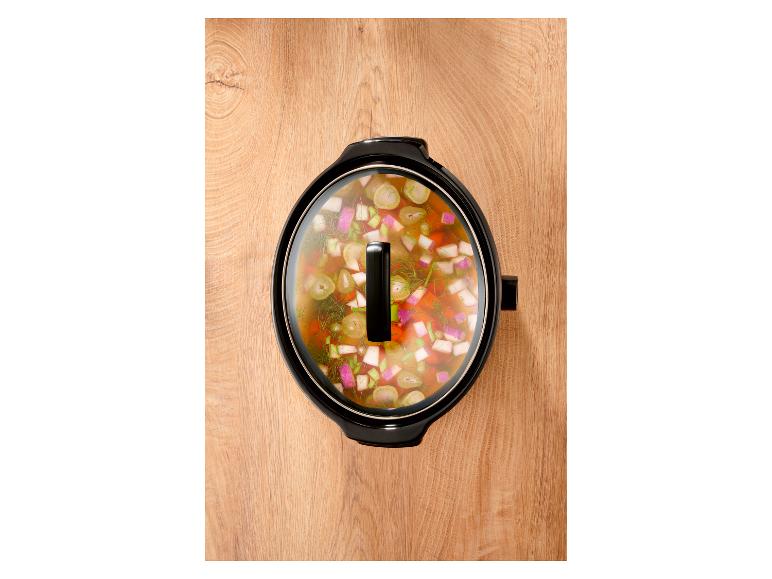 Slowcooker met groentestoofpot op een houten ondergrond, bovenaanzicht.