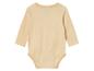 Een lichtbeige baby romper met lange mouwen.