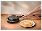 Hand houdt een elektrische crêpe- of pannenkoekenmaker vast, met een stapel kant-en-klare pannenkoeken op een bord.