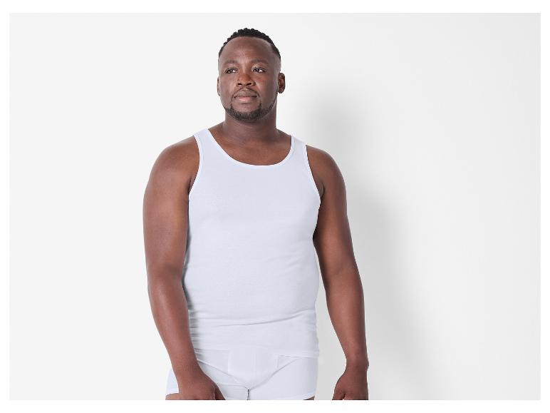 Man in een wit hemd en boxershorts.