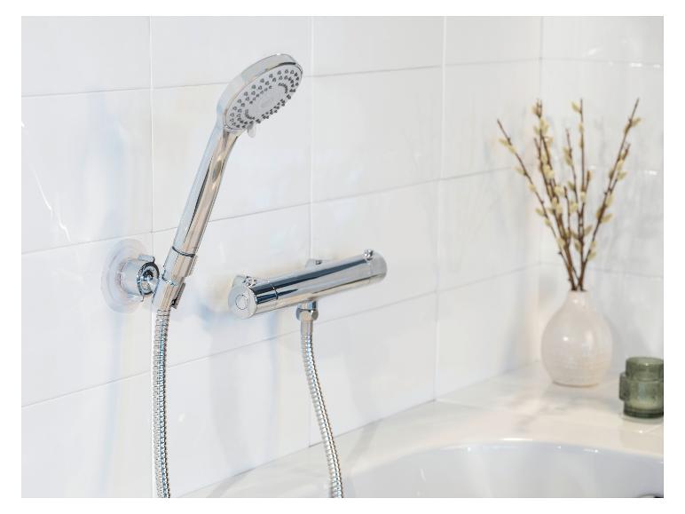 Moderne chromen doucheset gemonteerd op een witte tegelwand.