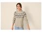 Vrouw in beige Fair Isle trui en jeans, lachend naar de camera.