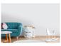 Kinderkamer met turquoise bank, witte opbergzakken en wit hobbelpaard.
