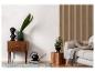 Moderne woonkamer met een houten ladekast, een grijze bank en een lattenwand.