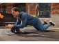 Een man traint op een mat met een buikspiertrainer.