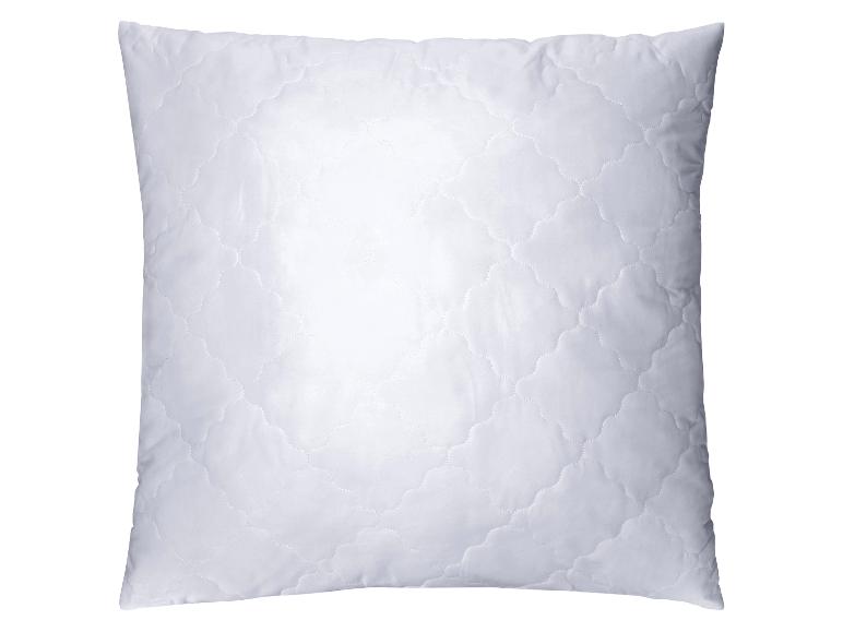 Wit, gewatteerd kussen met een patroon van gebogen lijnen.
