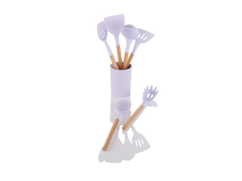 Lila keukenspullen met houten handvatten in een pot.