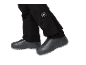Zwarte broek met wit logo en zwarte schoenen met grijze zool.
