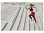 Vrouw in sportkleding rent trap op.