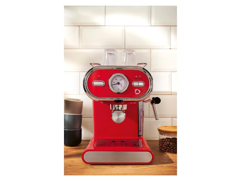 Rood espressomachine op een aanrecht met kopjes en koffiebonen.