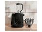 Zwarte keukenmachine met blender en roestvrijstalen kom op een houten aanrecht.