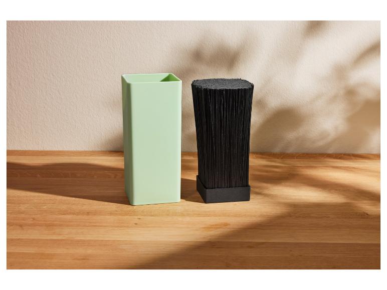 Twee moderne containers, lichtgroen en zwart, op een houten tafel.