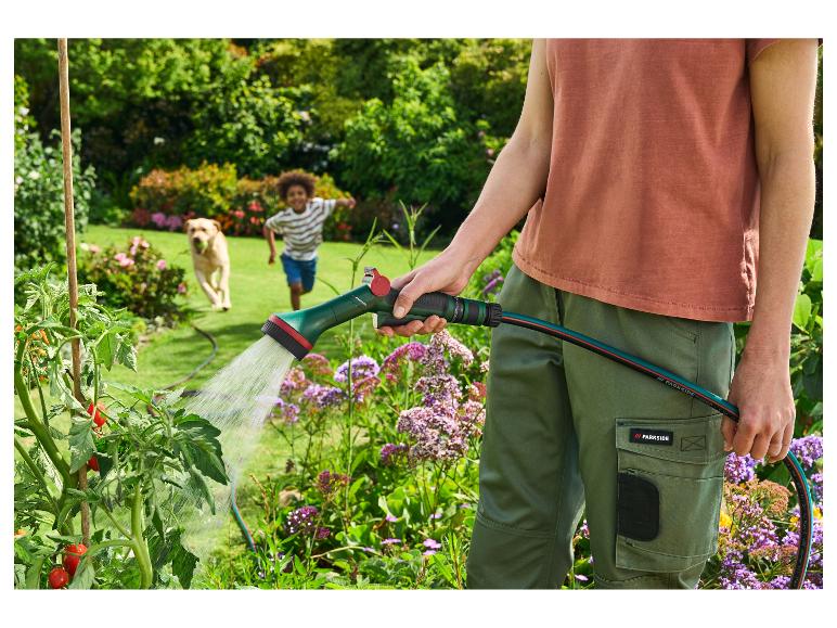 Planten water geven met een PARKSIDE gietpistool, kind en hond op de achtergrond.