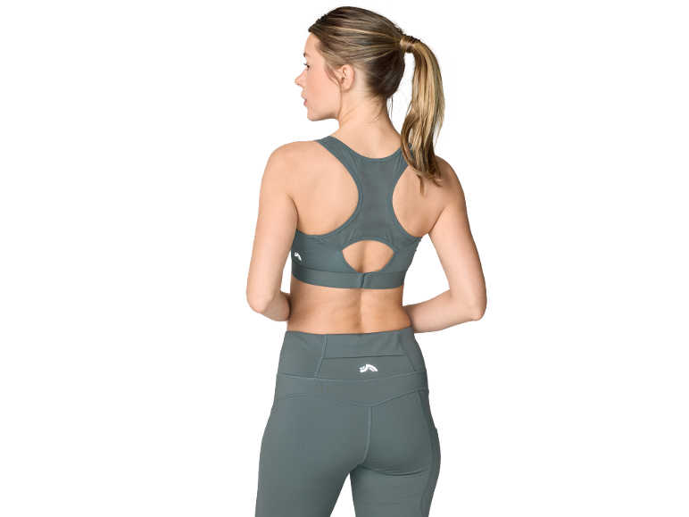 Vrouw van achteren in een grijze sport-bh en bijpassende legging.