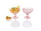 Twee roze dessert coupes met fruitdessert.