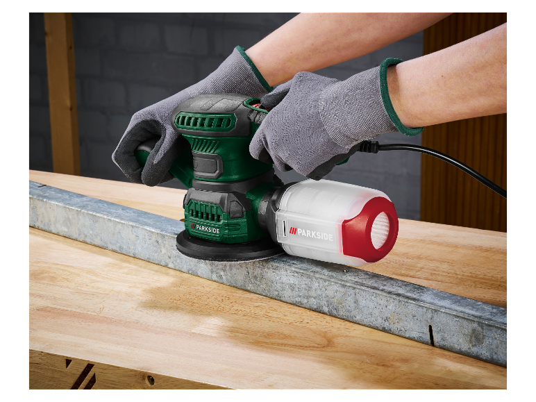Een man gebruikt een Parkside schuurmachine om een metalen onderdeel te schuren.