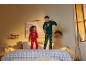Kinderen in kerstpyjama's springen op een bed met geruit beddengoed.