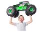 Een jongen houdt een Grave Digger Monster Jam monstertruckspeelgoed boven zijn hoofd.