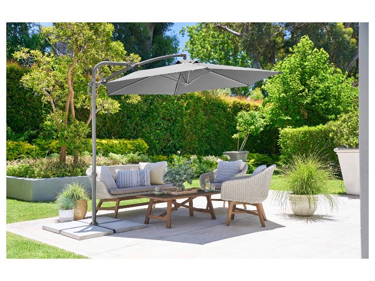 Tuinparasol, wicker tuinmeubelen en salontafel.