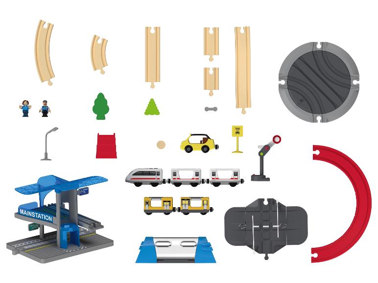 Een verzameling speelgoedtreinsetonderdelen inclusief rails, treinen, station en accessoires.
