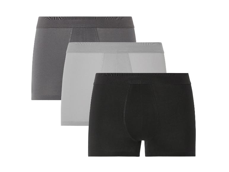 Drie boxershorts in zwart, grijs en donkergrijs.