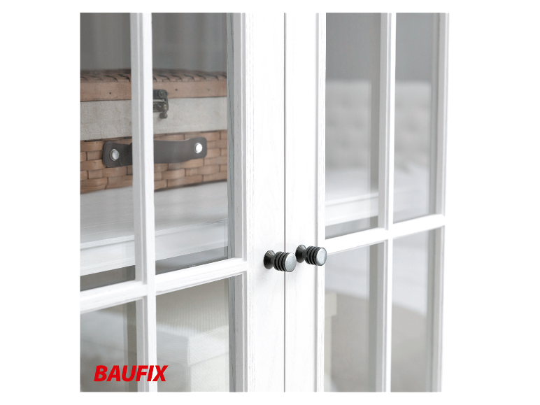 Witte BAUFix meubels met zwarte knoppen en een rieten mand.