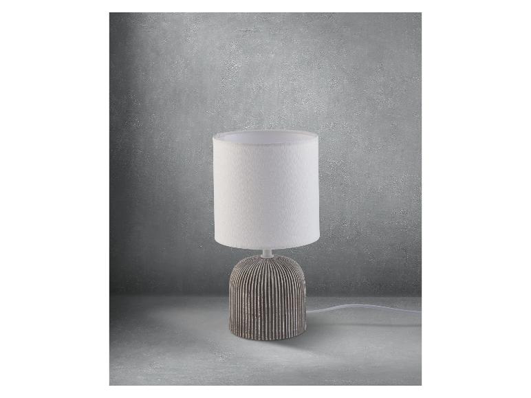 Moderne tafellamp met witte kap en grijs keramiek voet.