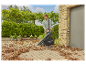 Een man gebruikt een Gardena bladblazer om herfstbladeren op te ruimen.