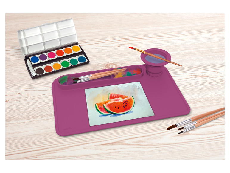 Een roze waterverfset met kwasten en een waterbakje.