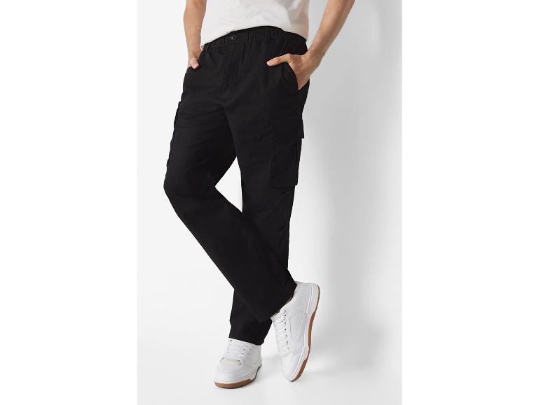 Zwarte cargbroeken en witte sneakers.