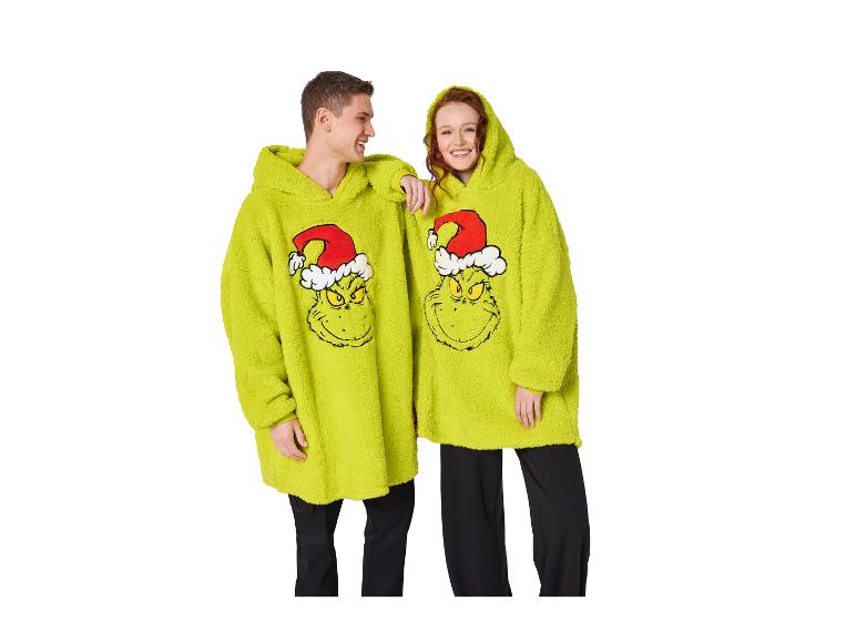 Twee mensen dragen oversized Grinch-hoodiedekens.