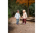 Twee kinderen in regenleding en laarzen plonzen in een plas in de herfst.