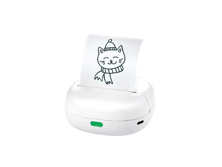 Witte draagbare printer met bedrukt papier waarop een tekening van een kat met muts en sjaal staat.
