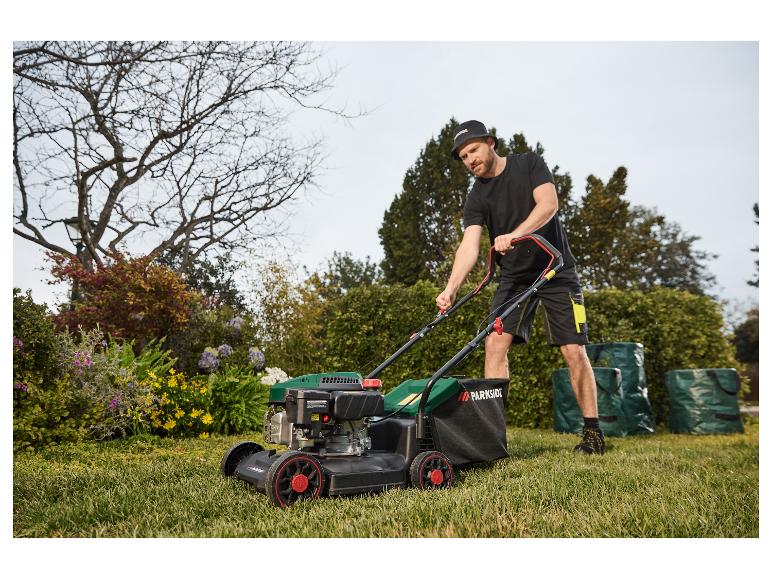 Een man gebruikt een Parkside grasmaaier in de tuin.
