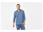 Lachende man in een blauw overhemd met lange mouwen en jeans.
