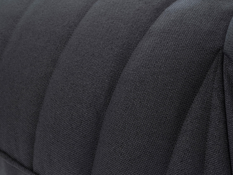 Close-up van een donkergrijze stoffen fauteuil.
