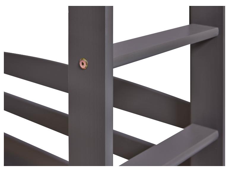 Detail van een donkergrijs houten bed.