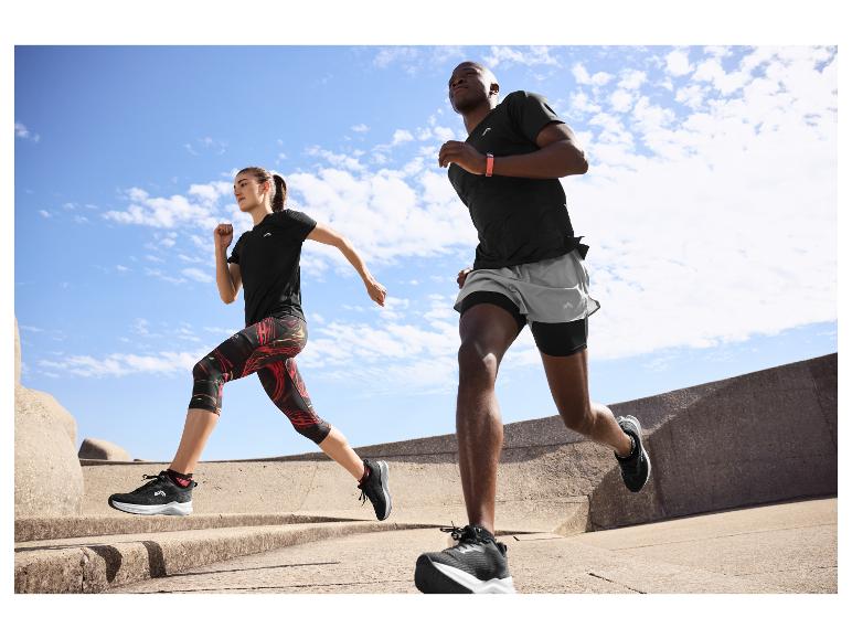 Twee mensen rennen buiten in zwarte en grijze sportkleding, met fitnesstrackers.