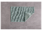 Een lichtgroen badmat op een grijze tegelvloer.