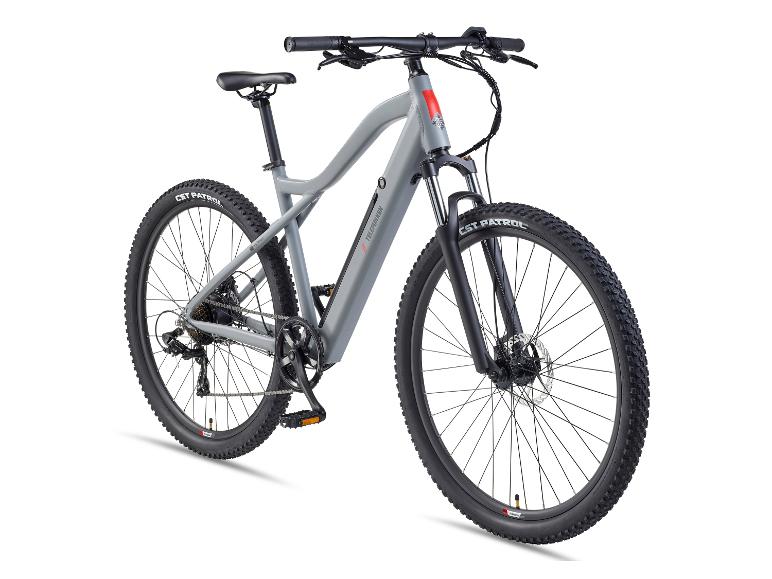 Grijze elektrische mountainbike met zwarte banden en vering, op een witte achtergrond.