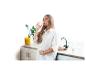 Zwangere vrouw drinkt gefilterd water in de keuken naast een BRITA Marella-kan.