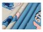 Stof met blauwe en beige cartoonprint met het woord 'STITCH'.