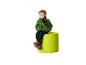 Jongen in groene fleecejas en jeans, zittend op een limoengroene poef.