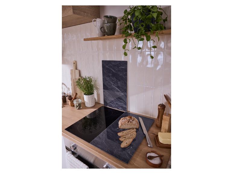 Aanrecht met inductiekookplaat, snijplank met brood, boter en kruiden.