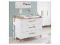 Witte commode met houten details en een witte plank met haken aan een lichtgroene muur.