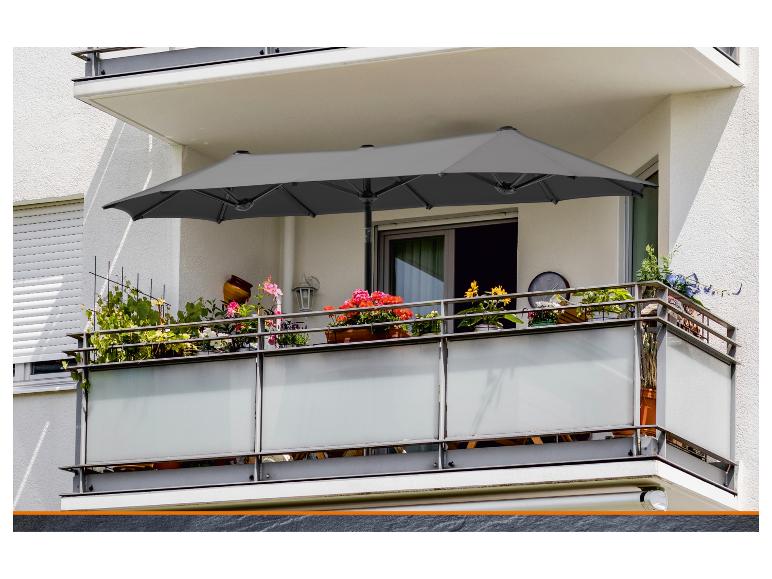 Grijze dubbele parasol op een bloemrijk balkon